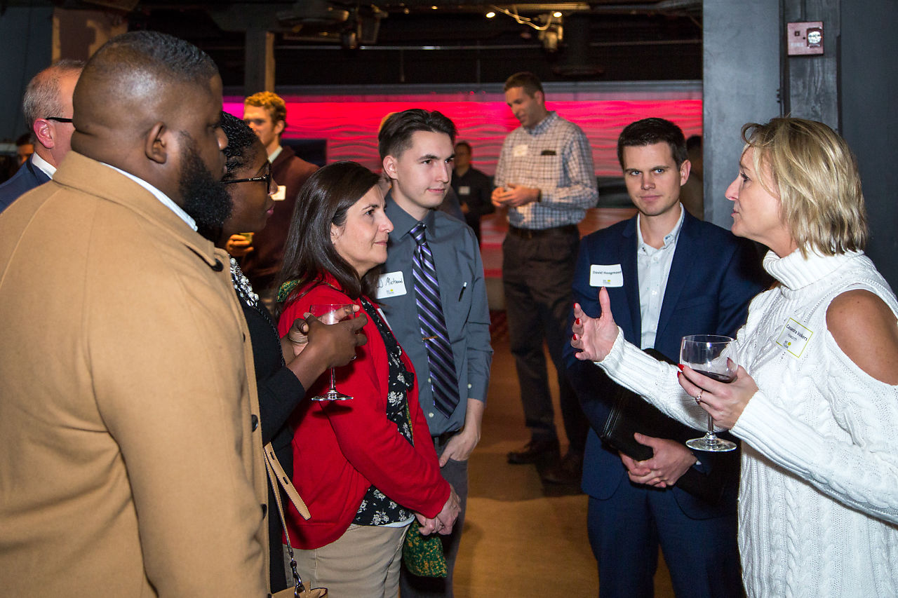 People gather and talk at a Back to Michigan networking event
