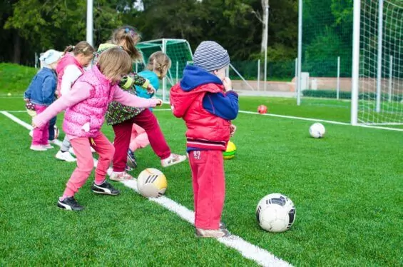 Group of toddlers playing soccer.