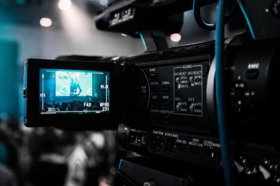 Close-up of camera screen filming a group of people watching a movie.