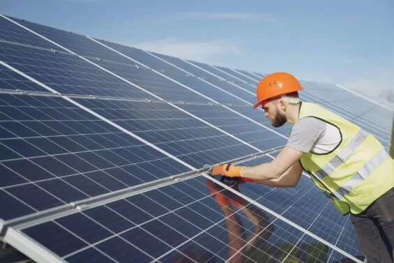 Man works on solar panel.