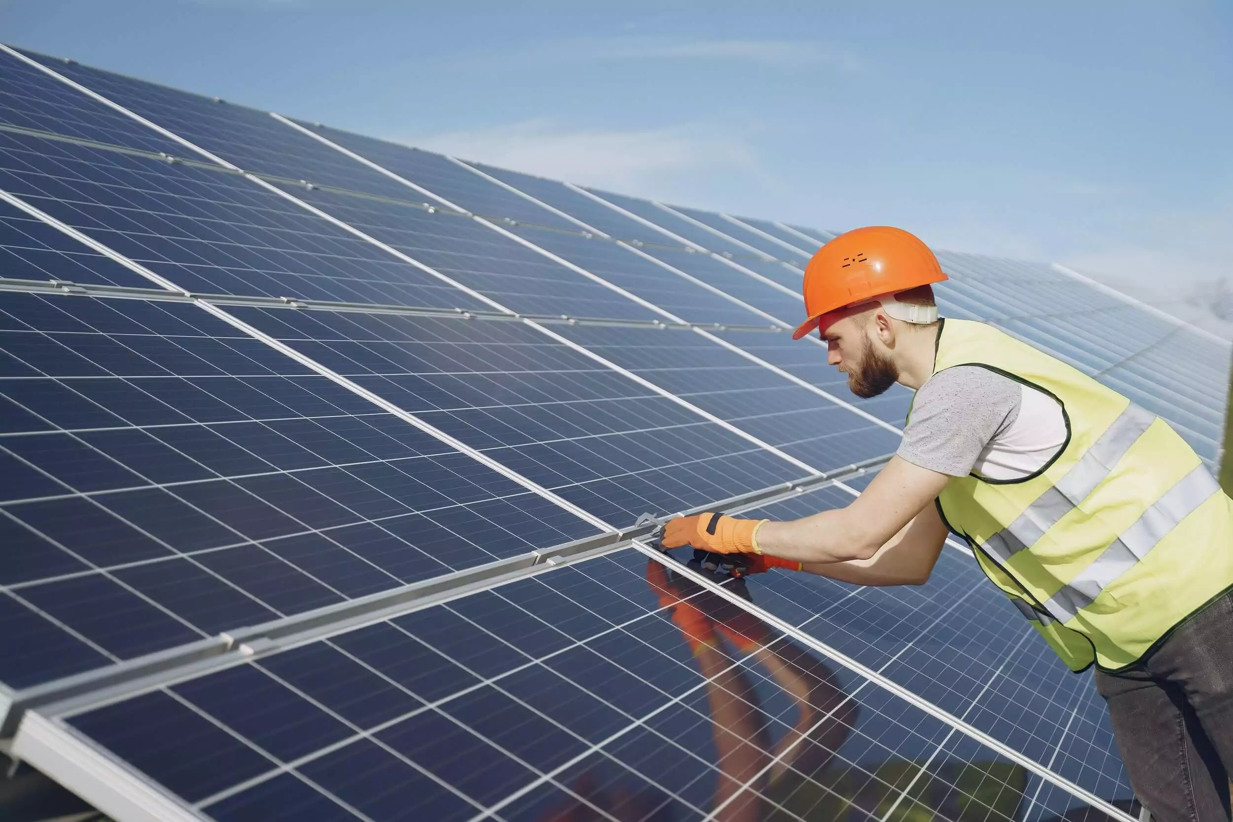 Man works on solar panel.