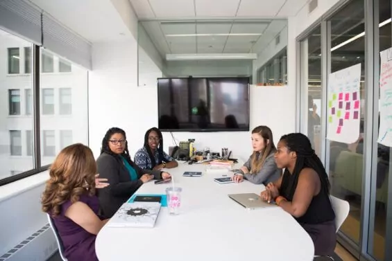Group of women gathered in conference room.
