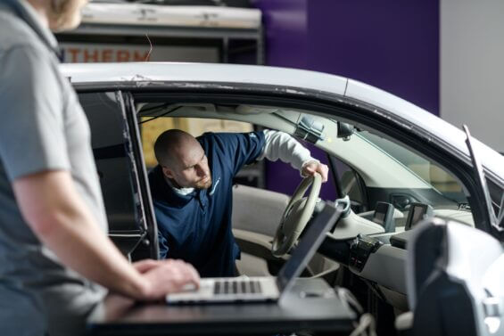 Man working on the inside of an electric car.