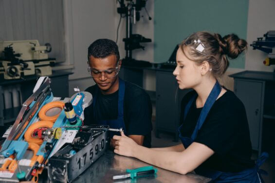 Two students work on creating a robotic tool.
