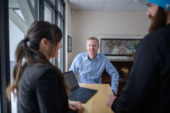 Man in professional attire smiling during meeting.